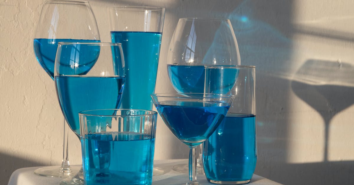 Nonalcoholic Substitute for Marsala Wine - Transparent glasses filled with blue alcoholic drink standing on white tablecloth in sunlight