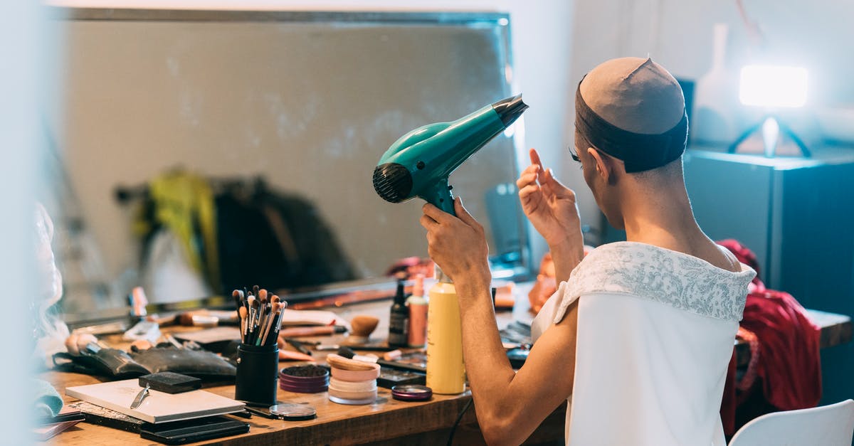 Non-dairy creamer, dry - Unrecognizable ethnic man drying hair in front of mirror