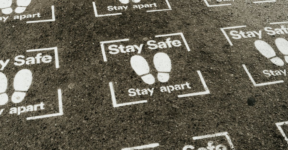 Non-fat way of preventing legumes from frothing during canning - From above white sign of feet and inscription Stay Safe Stay Apart painted on asphalt road during coronavirus outbreak