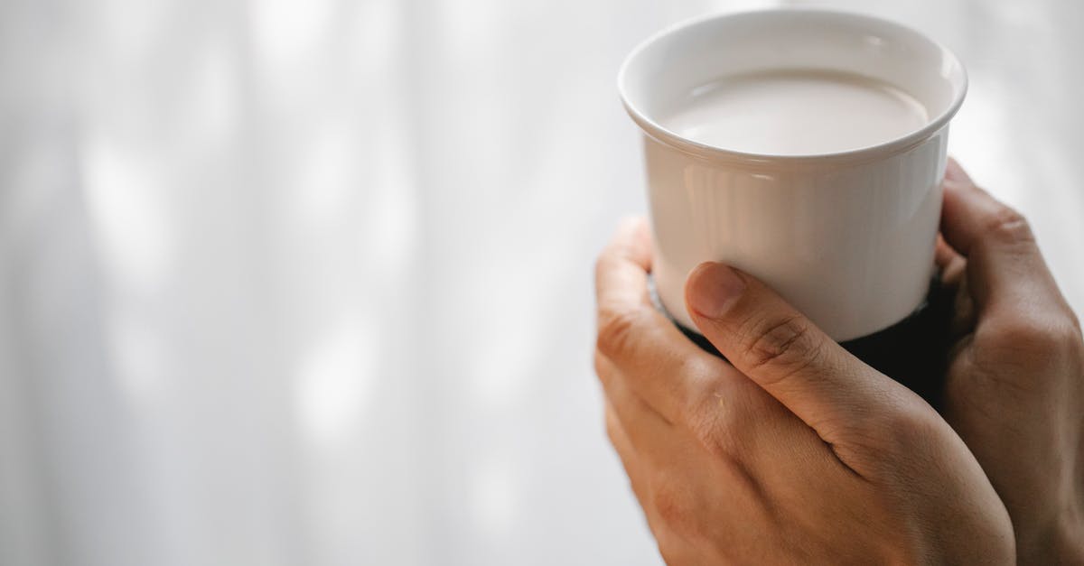 Nutrition value: cold or warm milk? [closed] - Crop faceless person holding cup of hot milk