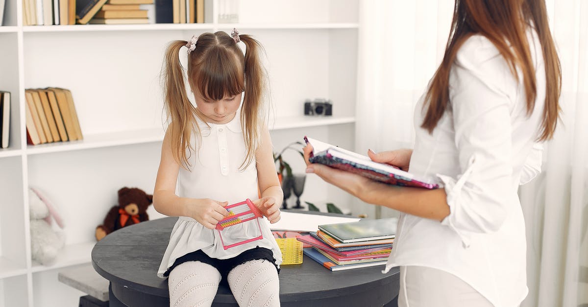 Obtaining flavour with less fat/sugar/salt - Little child in white dress using abacus for mental arithmetic while sitting on black round table with textbooks and school items against bookshelf during home education with crop young female tutor standing near with diary in hands