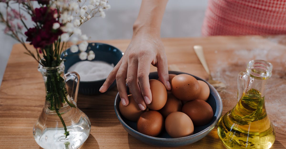 oil for cooking eggs [closed] - Unrecognizable Female Hand Choosing Egg from Bowl