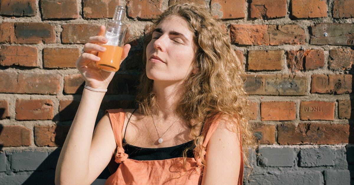 Old, unpasteurized orange juice has extra tang - Woman Drinking Juice from a Bottle 