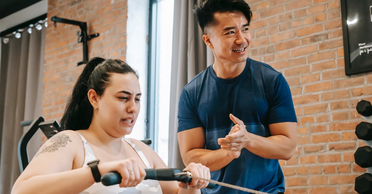 Omelet help.... gah why is it so hard? [duplicate] - Low angle of smiling ethnic male trainer clapping hands to overweight female training on rowing machine in gym