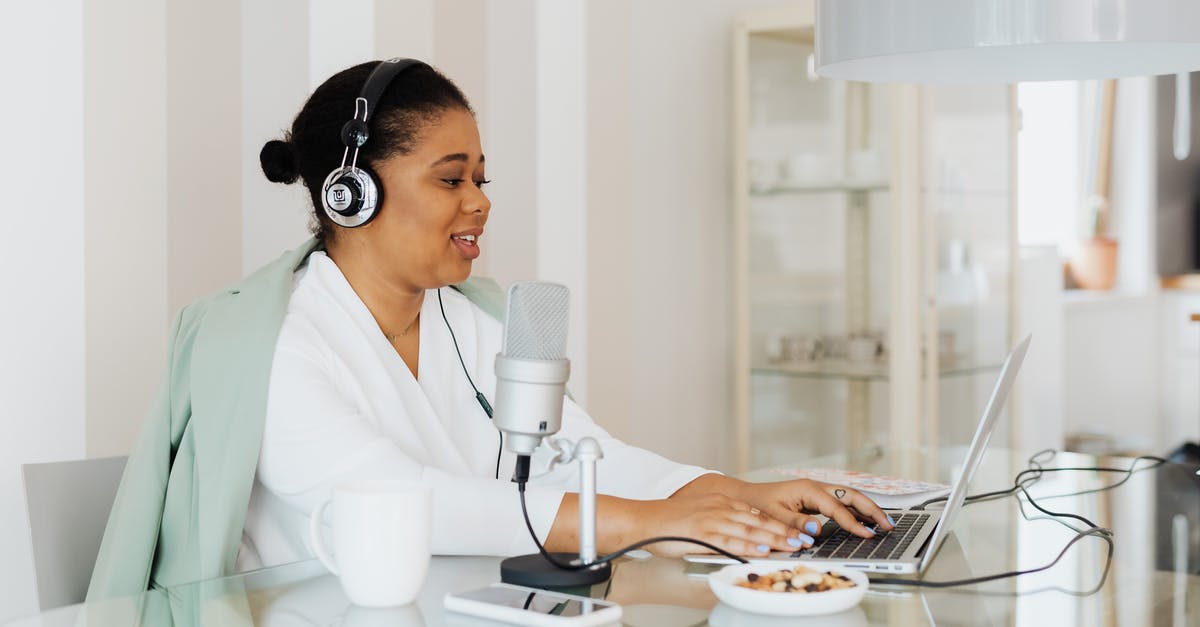 One Cup in Grams - Woman Sitting Behind a Desk Wearing Headphones and Using a Microphone and Laptop 