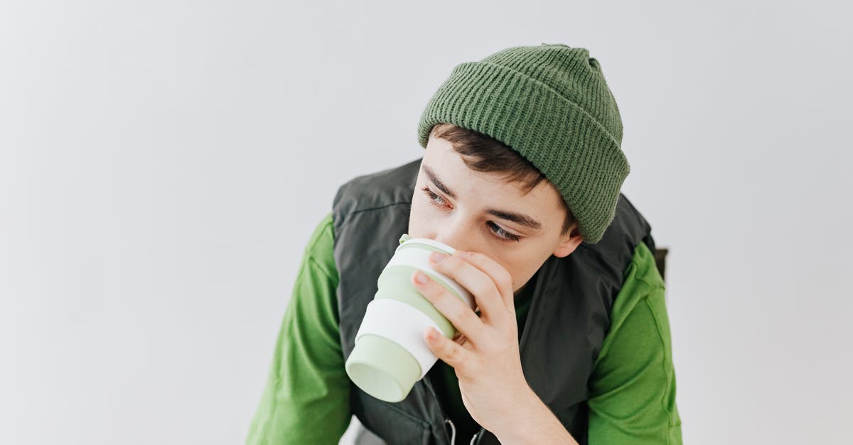 One Cup in Grams - Man in Green Shirt Drinking from White Plastic Cup