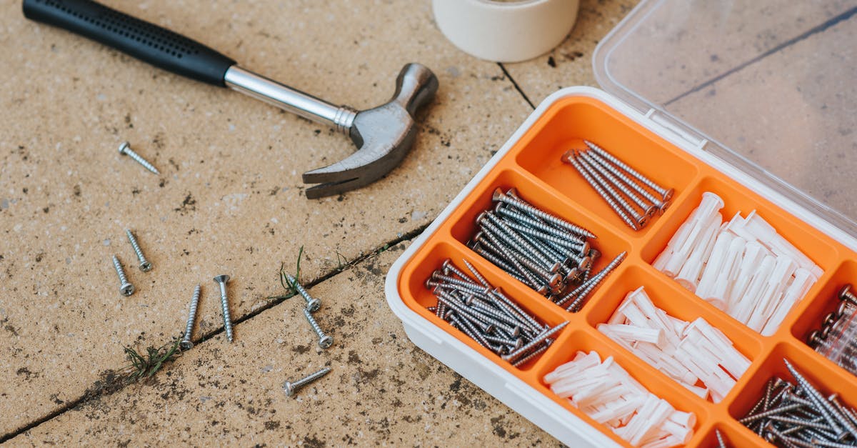 On-top-of-fridge storage - Screws and repair tools in box near hammer