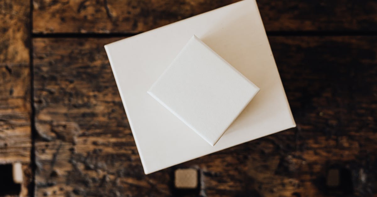 On-top-of-fridge storage - Stack of white carton boxes on wooden table