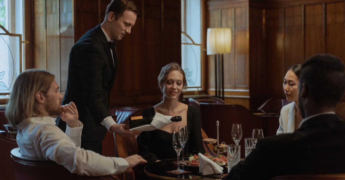 Opening wine bottle with rounded top using a waiter's friend - Photo of a Waiter Pouring Wine into Glasses