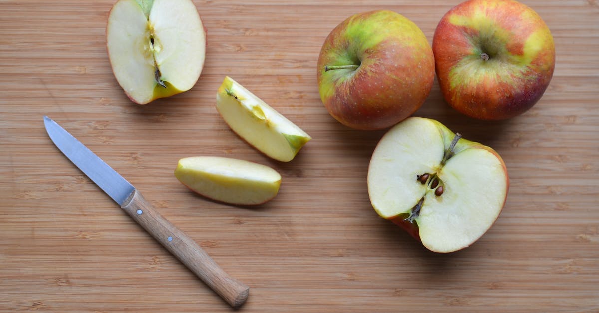 Optimal shape to cut apples for apple pie - Slices of ripe apples and knife on wooden surface