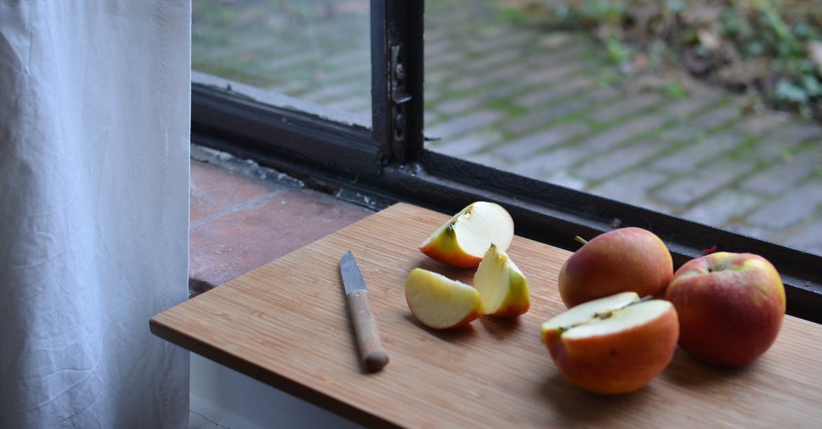 Optimal shape to cut apples for apple pie - Ripe sliced apples on cutting board with knife near window