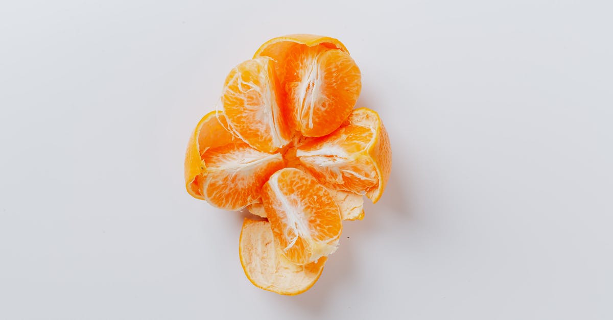 Orange peel loose/baggy around orange: Is that a problem? - From above of fresh peeled juicy tangerine divided into five equal slices on gray background