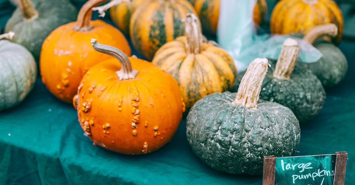 Orange peel loose/baggy around orange: Is that a problem? - Colorful raw pumpkins with pedicels on green cloth with price tag in local bazaar in daytime