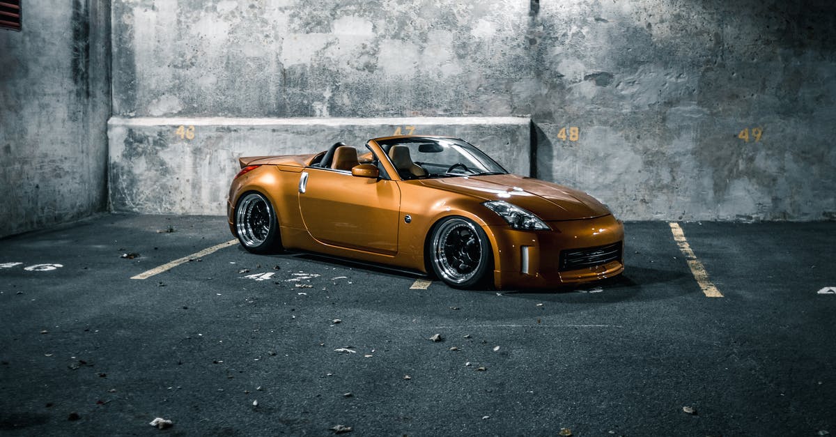 Orange spots on dry chickpea - Modern racing car on pavement near shabby wall at night