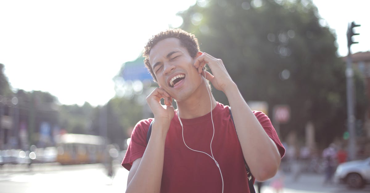 Oven does not have a temperature notification sound - Delighted African American young male in casual wear enjoying songs in earphones on street and singing along loudly while standing in city with closed eyes