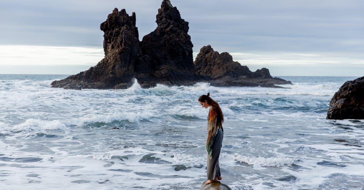 Over watered single layer - Side view of lonely sad female standing on stone in front of storming ocean