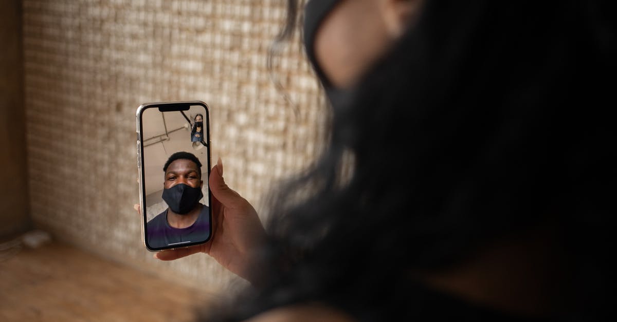 Oxtail soup, what is the normal simmer time? - Back view of crop anonymous female talking to ethnic male beloved in fabric mask during video call on cellphone