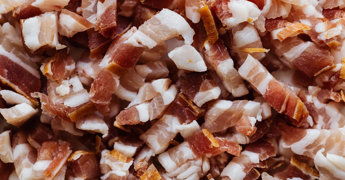 Pancetta leaking into cheesecloth - Closeup top view heap of delicious scrumptious pork bellies bacon cut into small slices before cooking process