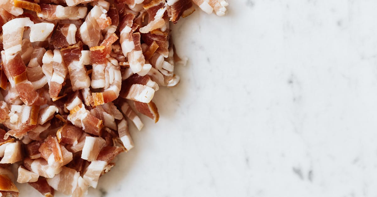 Pancetta leaking into cheesecloth - Heap of sliced bacon on marble surface