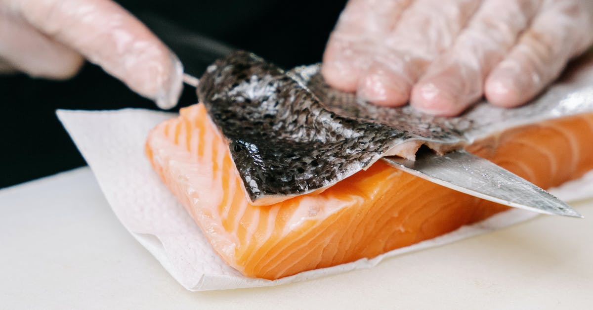 Pan-frying fish filets with skin on - A Person Removing the Skin of a Salmon