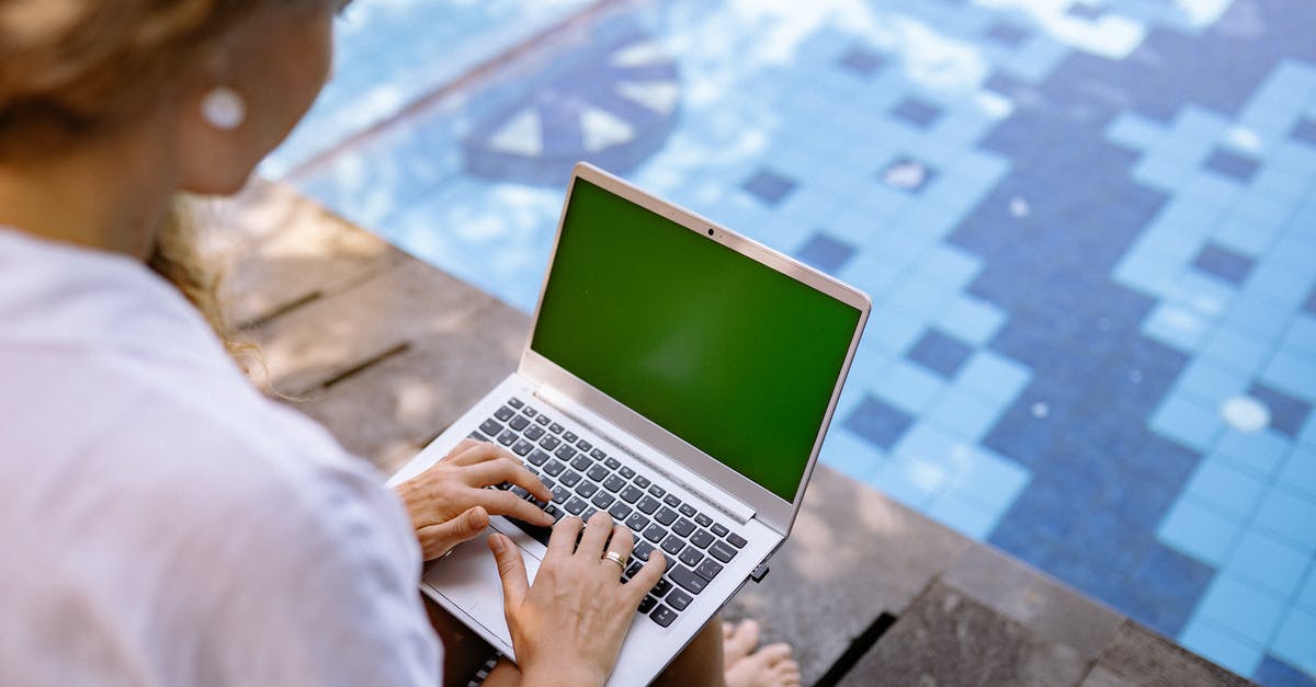 Pans with ceramic coating useful? - From above of crop unrecognizable barefoot female remote worker surfing internet on netbook with chromakey screen while sitting near swimming pool in sunlight