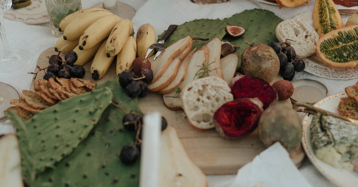 Papaya ripe or over ripe - From above of fresh fruit with snacks green opuntia and bread on white cloth for picnic