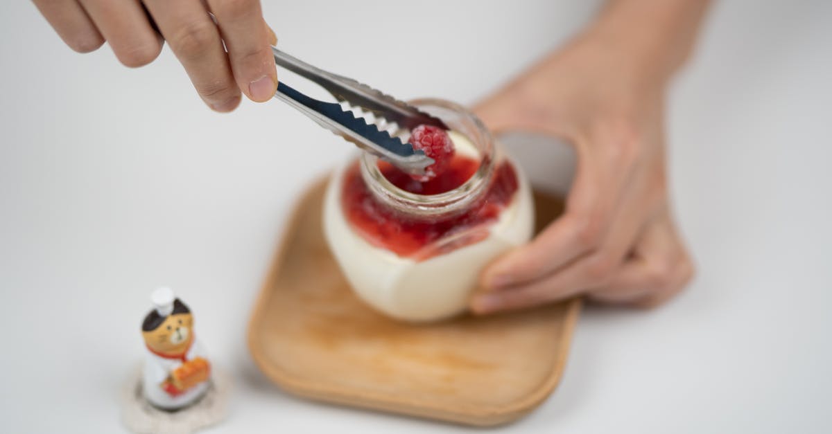 Pasteurized milk that has gone sour - Crop person decorating yogurt with berries