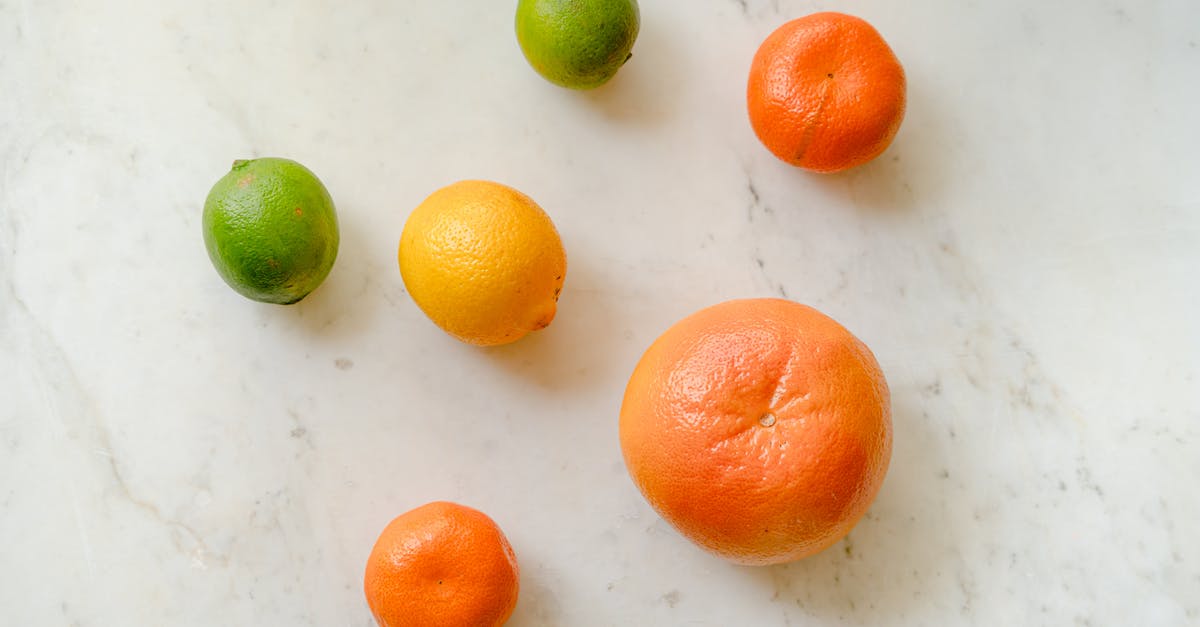 Patina peel off on newly seasoned wok - Top view of fresh whole grapefruit lemon tangerines and limes placed on marble surface