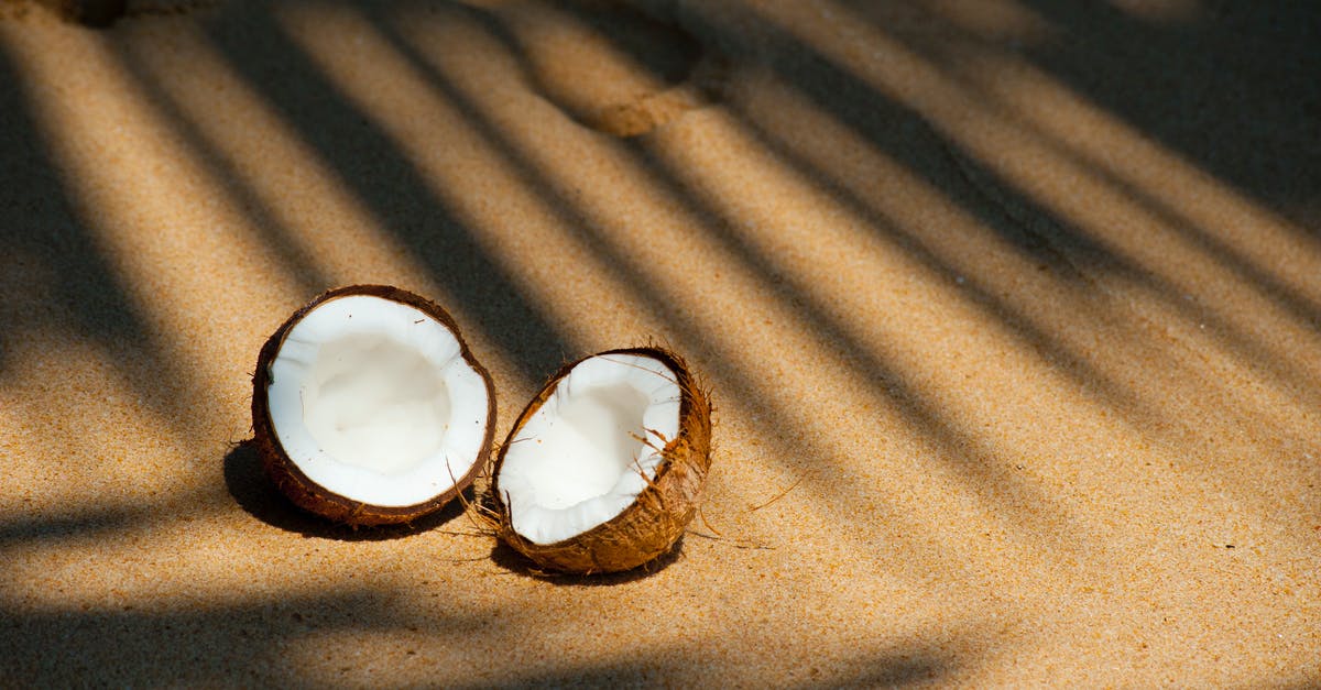 Peeling coconut meat from shell - Opened Coconut on Sands