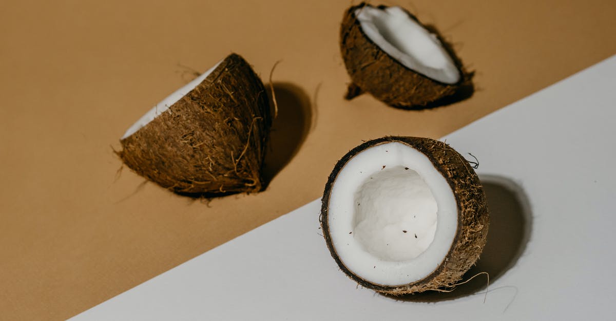 Peeling coconut meat from shell - A Coconut Fruit Cracked Open