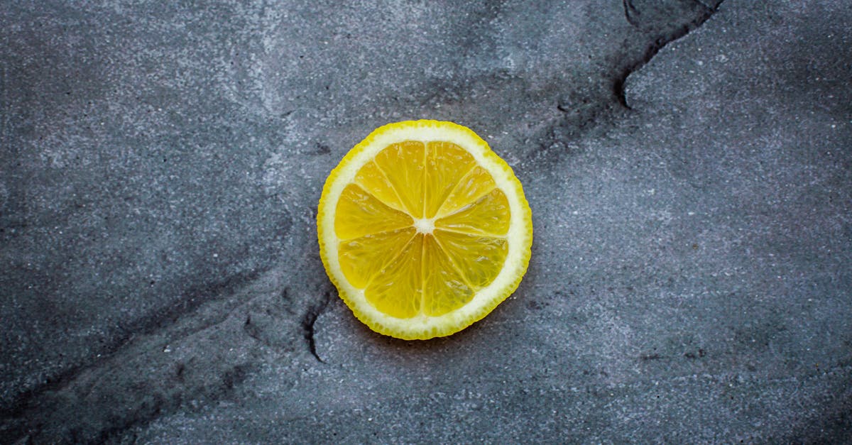 PH and sour / acid taste - Top view ripe sour lemon slice placed on dark gray cracked background in studio