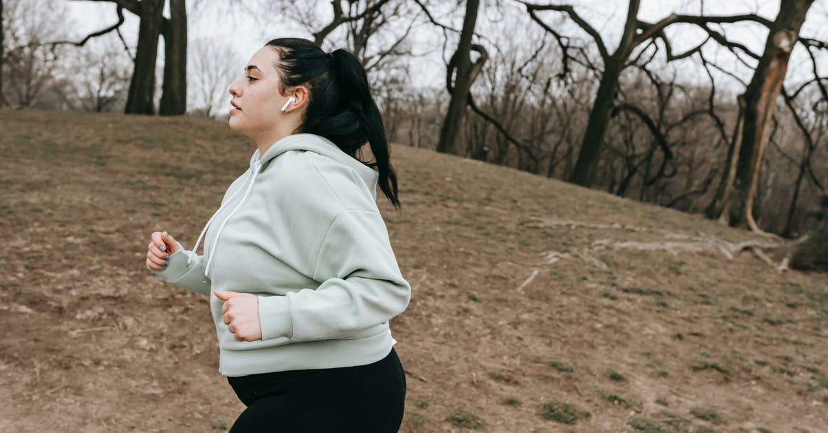 Physical method to season steaks - Plump sportswoman jogging in autumn park