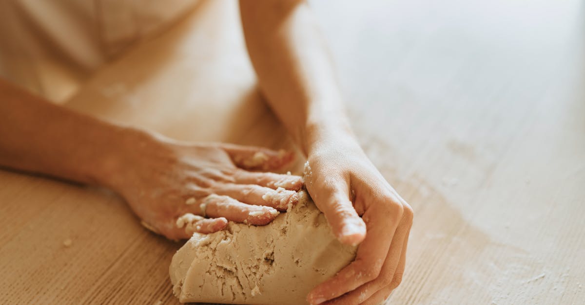 Picking up wet dough - A Person Making a Dough