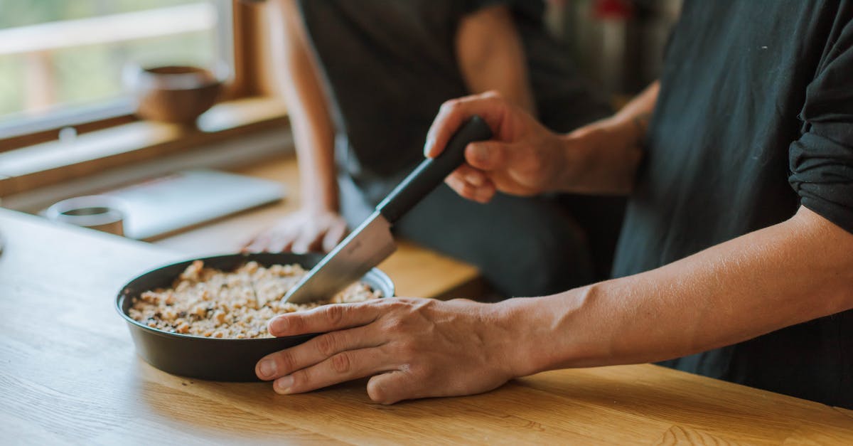 pie pan question - Person Holding Black Handled Knife Slicing Food in a Deep Pan