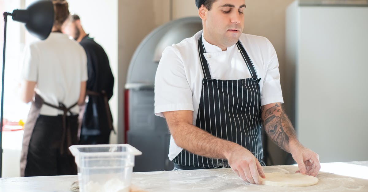 Pizza dough keeps breaking through plastic - Man in Striped Apron Making Dough