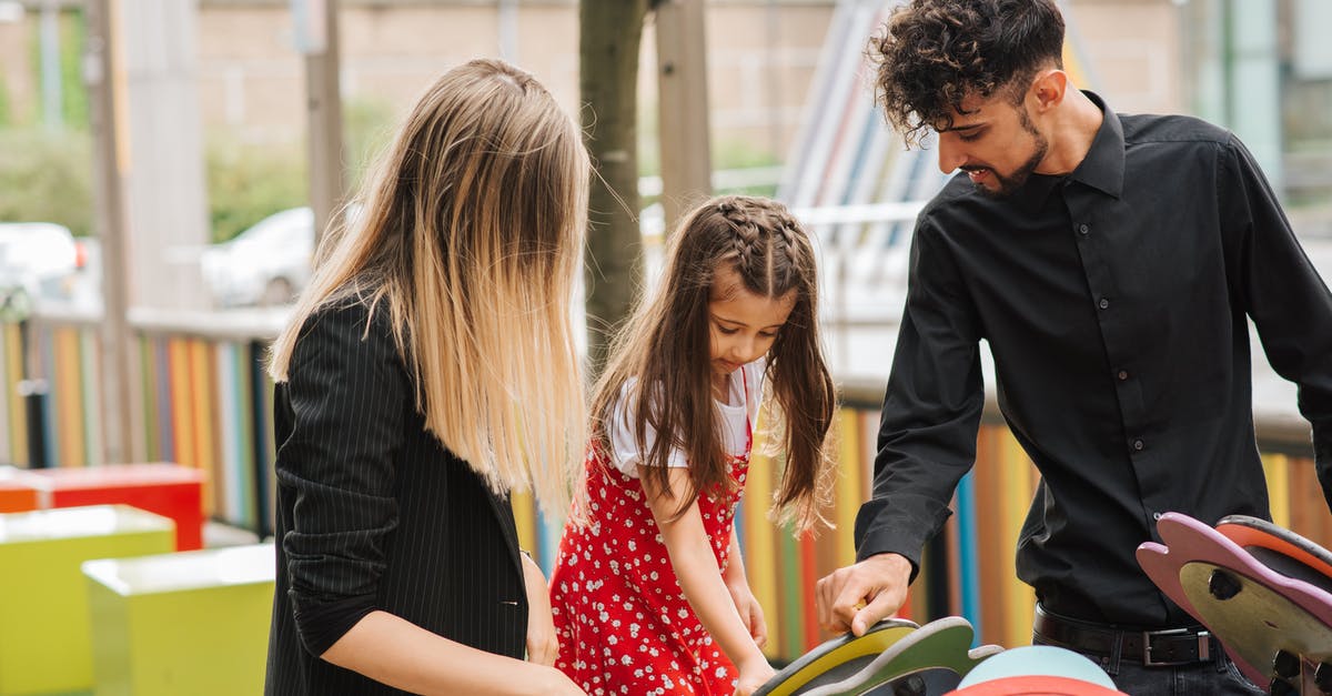 Plastic on grill: is my family safe? - Little girl playing on playground with support of mother and father in casual clothes in summer day