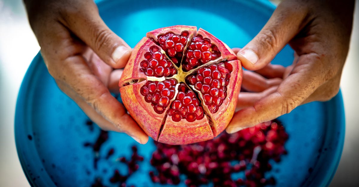 Pomegranate juice ceviche - Close-up Photo of Person Holding Pomegranate Fruit