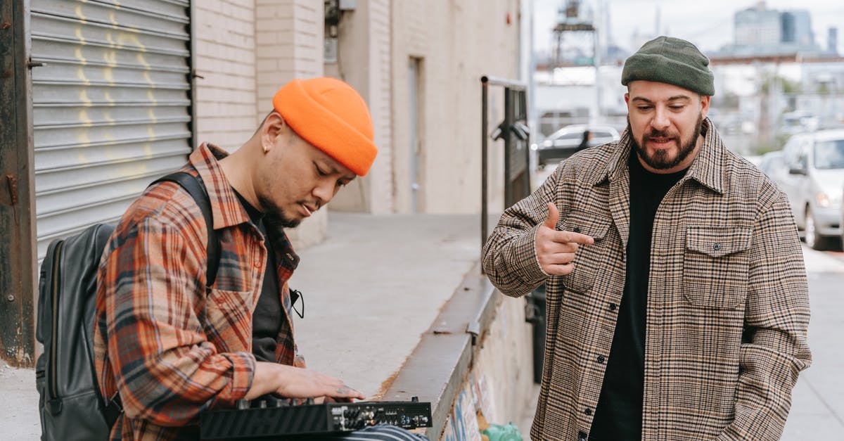 Popped lid in pressure canning - Man in Black and Brown Plaid Coat and Orange Knit Cap Standing Beside Man in Black