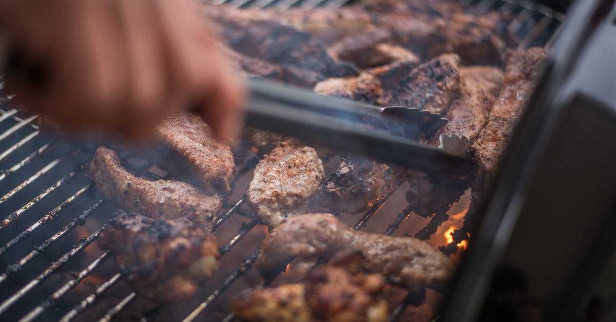 Pork butt roast: slicing temp vs pulling temp - Crop faceless person grilling meat on brazier