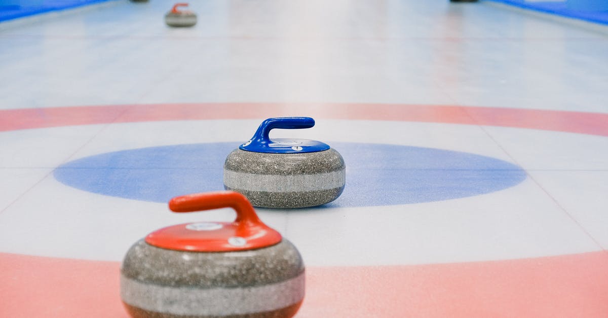 power outage/frozen meat - Red and blue handled curling stones placed on circles of house of ice arena while competition