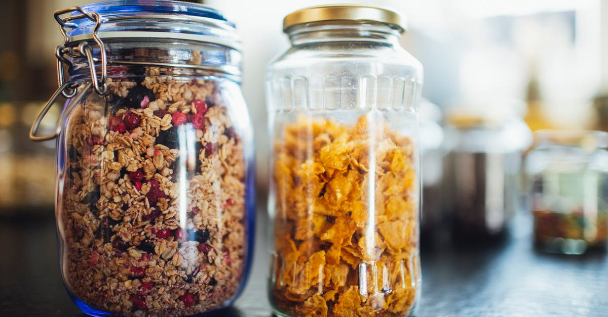 Premixed Bircher muesli (cereal) - soak overnight or ready-to-eat? - Glass jars with healthy cornflakes and muesli placed  on table in kitchen