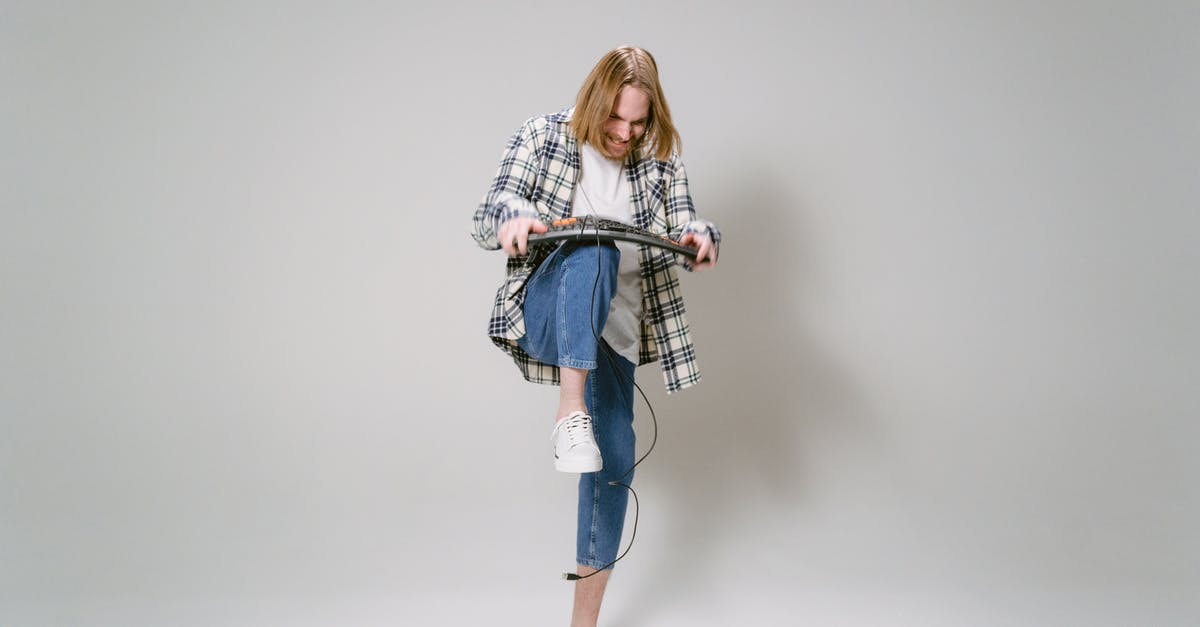 Prep before breaking down chicken - Woman in White and Black Long Sleeve Shirt and Blue Denim Jeans Standing and Holding Black