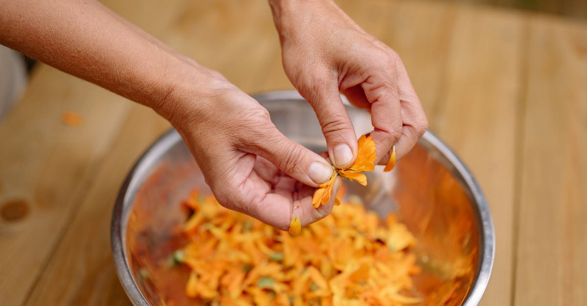 Preparation Techniques for Tilapia Filets - Woman Tearing Orange Petals into a Metal Bowl