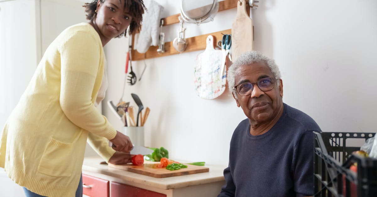 Preparing / pre-cooking hash browns / home fries - A Woman in Yellow Cardigan Preparing a Food while an Elderly Man Sitting on the Side