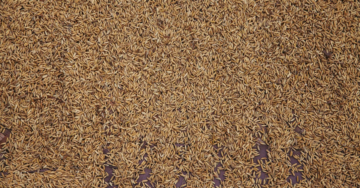 Preparing Brown Rice - From above of pile of raw brown rice scattered on table as background