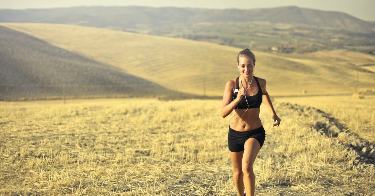 Preparing Meats using Dry Rubs - Powerful young female athlete in activewear running along hill on background of mountainous landscape and listening to music in earphones during cardio training