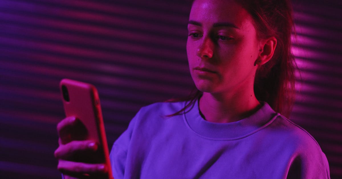 Preparing minced garlic the night before using them - Pensive female browsing smartphone in dark room with colorful lights