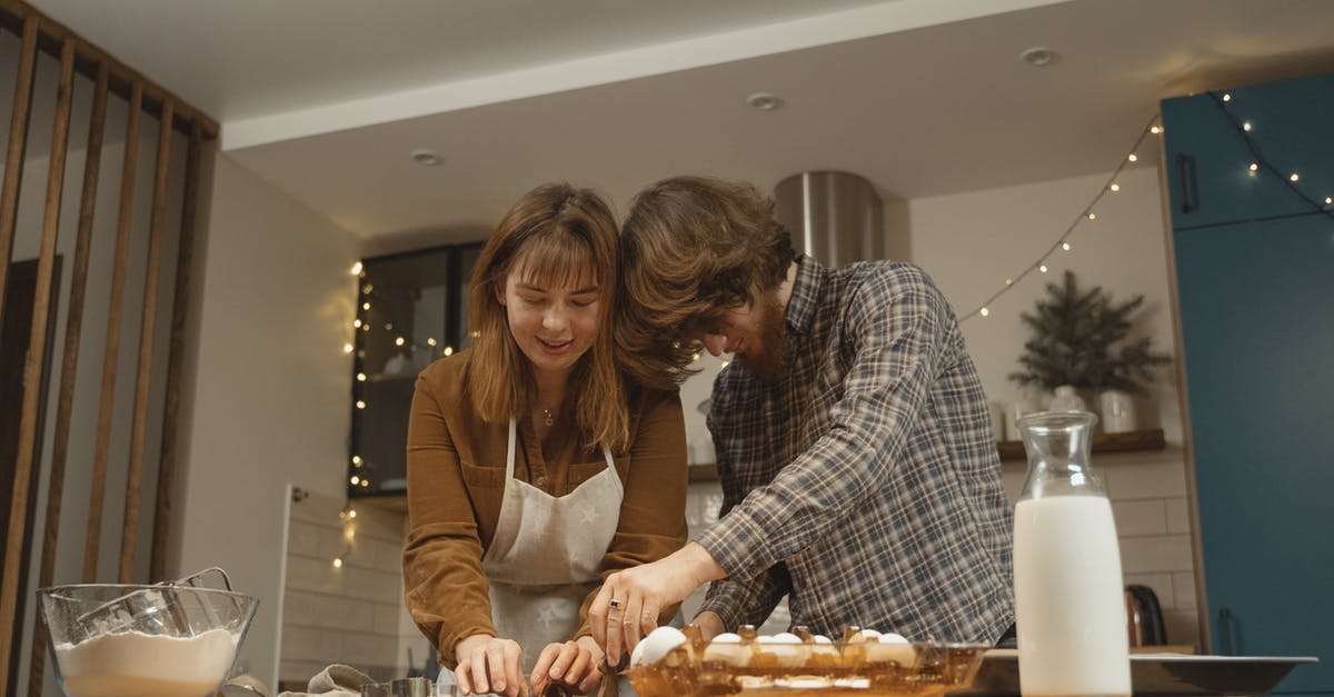 Preparing soy milk at home - Man and Woman Standing at the Kitchen Table 