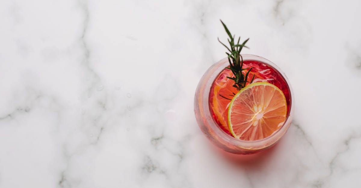 Preserved Lemons: is it ok if they are above the liquid - Glass with cocktail with lemon and rosemary placed on table