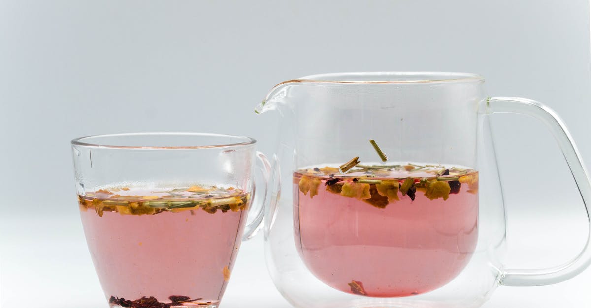 pre-soaking tea in cold water prior to brewing - Glass transparent teapot with fresh brewed herbal tea placed near cup in studio